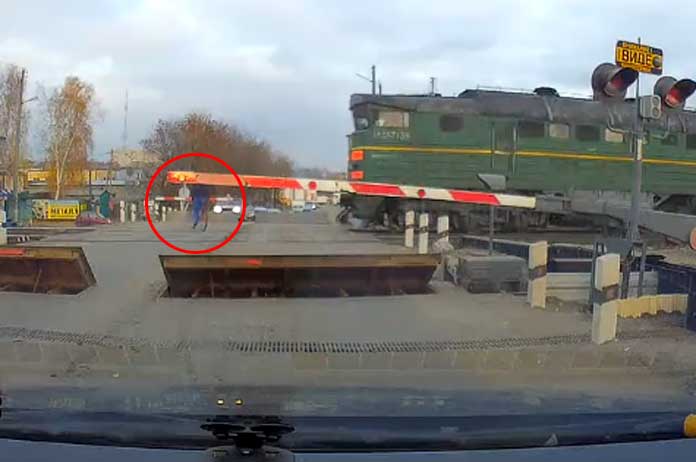 Dat scheelde geen haar: ongeduldige fietser ontsnapt nipt aan aanstormende trein (video)
