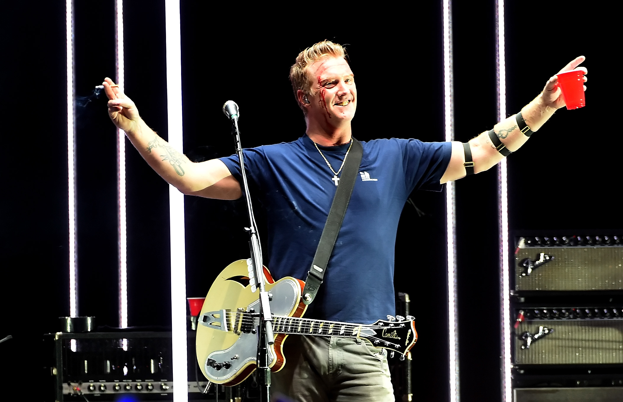 Queens of the Stone Age-frontman trapt fotografe in gezicht tijdens optreden