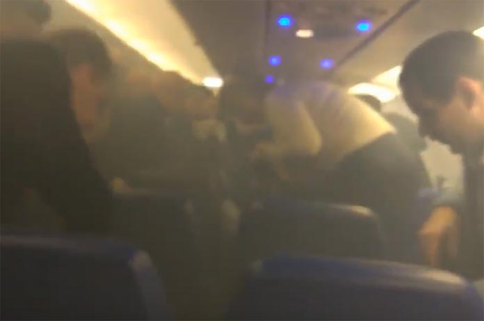 Mobiele oplader vat vuur in vliegtuig (video)