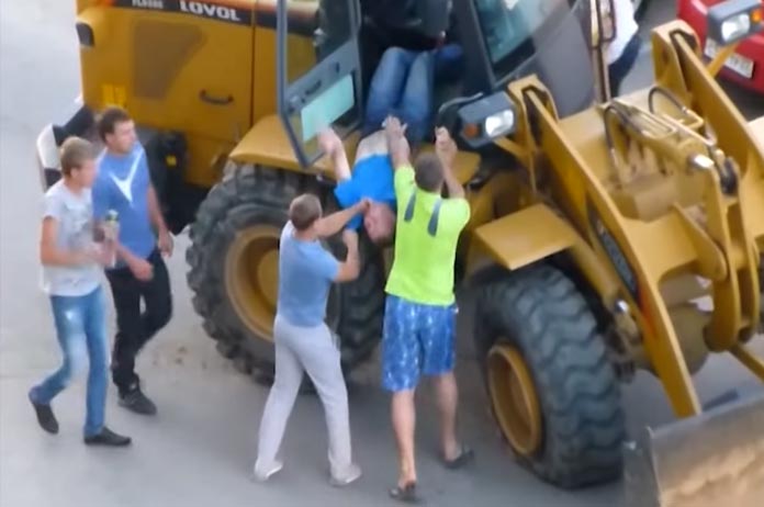 WTF: dronken bestuurder in wiellader ramt geparkeerde auto’s en krijgt stevig pak rammel (video)