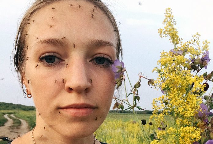IN BEELD. Deze vrouw haar gezicht zit vol muggen