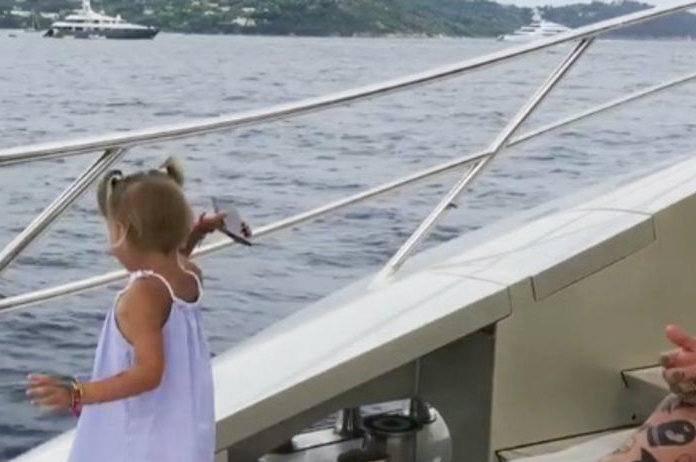 Meisje is het beu dat papa altijd met zijn gsm bezig is en smijt het ding in zee