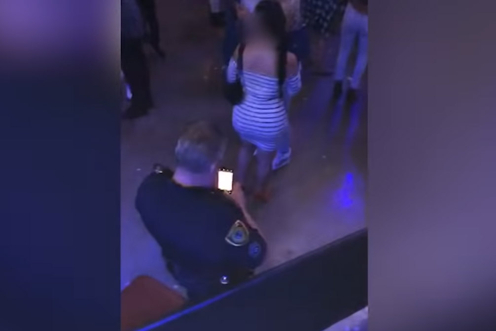 Betrapt: voyeuristische politieagent neemt stiekem foto van kont tijdens concert (video)