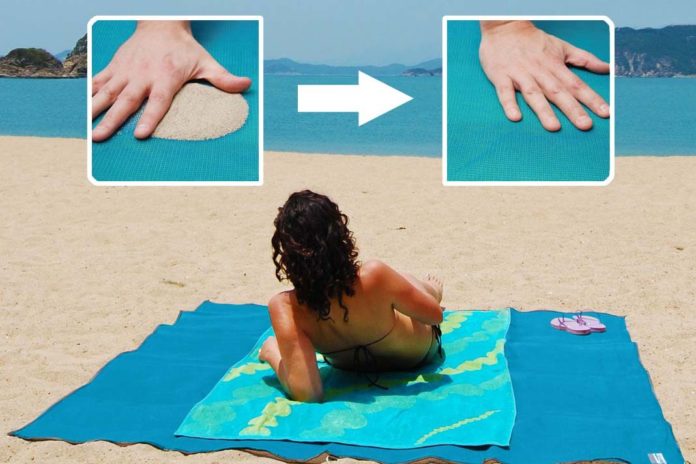 Bizar. Dankzij dit strandlaken kan je volledig zandvrij zonnen