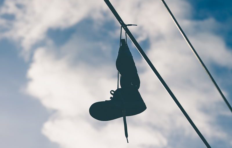 Waarom mensen schoenen over een elektriciteitsdraad hangen