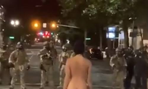 VIRAAL: Poedelnaakte betoogster ‘poseert’ voor ordetroepen (video’s/foto)