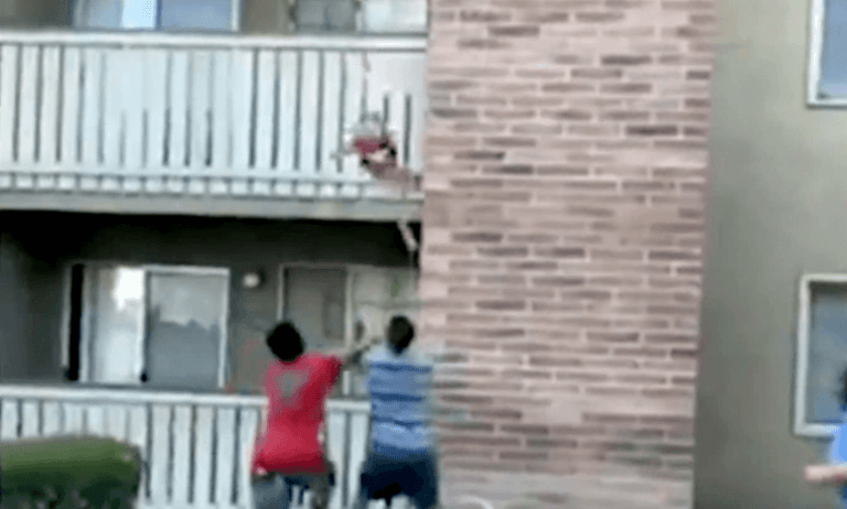 Ongelooflijk: man vangt kind dat uit brandend gebouw valt (video)