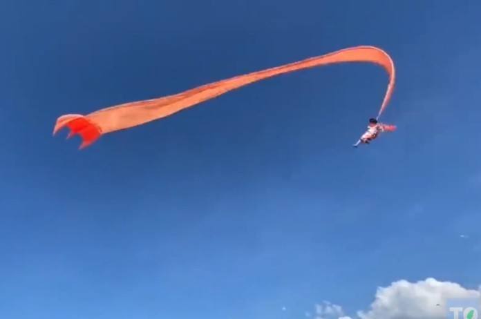 IJzingwekkende beelden: peuter raakt verstrikt in vlieger en wordt meegesleurd door windvlaag (video)