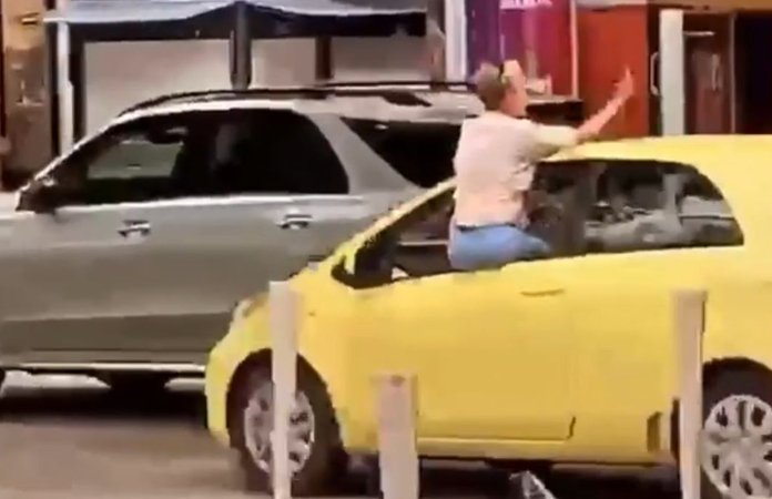 Vrouw hangt uit autoraam en steekt middelvinger op, maar let niet goed op de weg… (video)