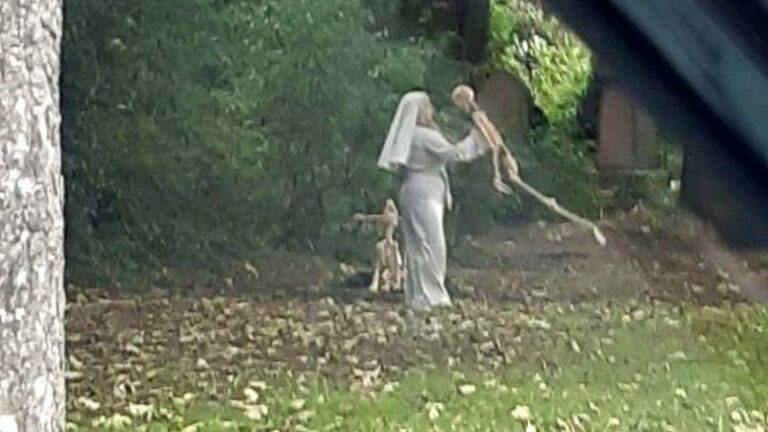 Macaber zicht: vrouw verkleed als non danst met skeletten op oud kerkhof (foto’s)