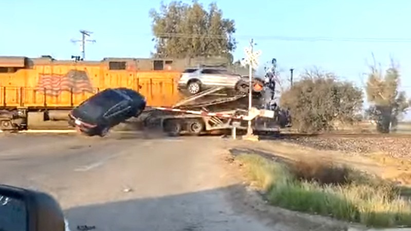 Goederentrein ramt vrachtwagen die stilstaat op sporen VOLLEDIG uit elkaar! (video)