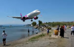 Lage vliegtuiglanding net boven de hoofden van toeristen zorgt voor waanzinnige beelden! (video)