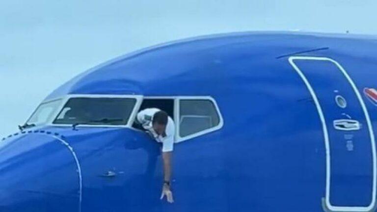 Piloot hangt uit venster van de cockpit om gsm van passagier te vangen (video)