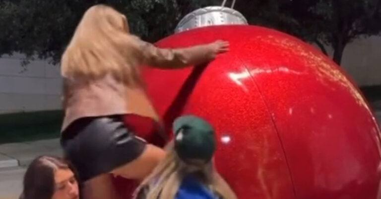 Dame probeert op gigantische kerstbal te kruipen, maar dat loopt PIJNLIJK af! (video)