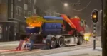 Strooiwagen komt in de problemen op spekgladde weg. Behulpzame cafégangers grijpen in! (video)